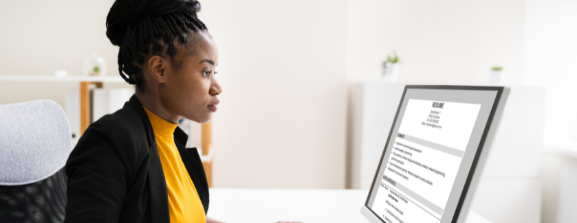 Person looking at a resume on a laptop screen.